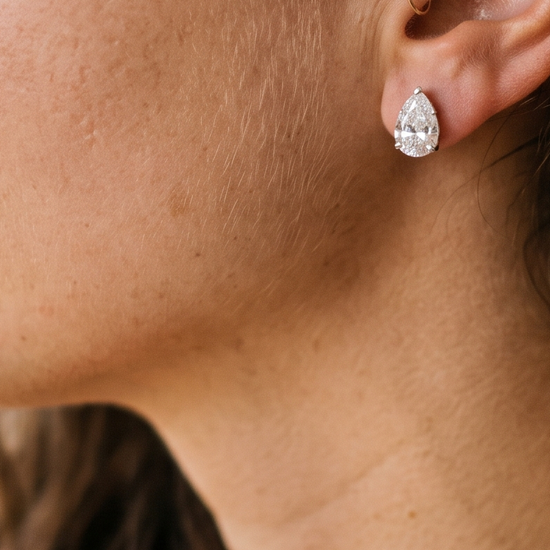 Close-up of a woman wearing sparkling lab-grown diamond stud earrings in natural light