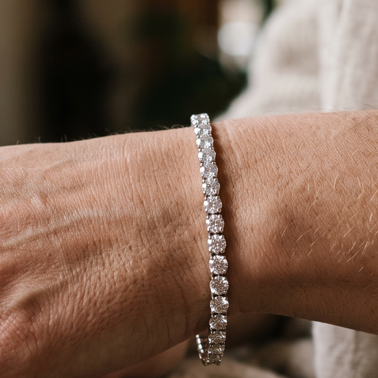 Woman's wrist wearing a lab-grown diamond tennis bracelet in natural light