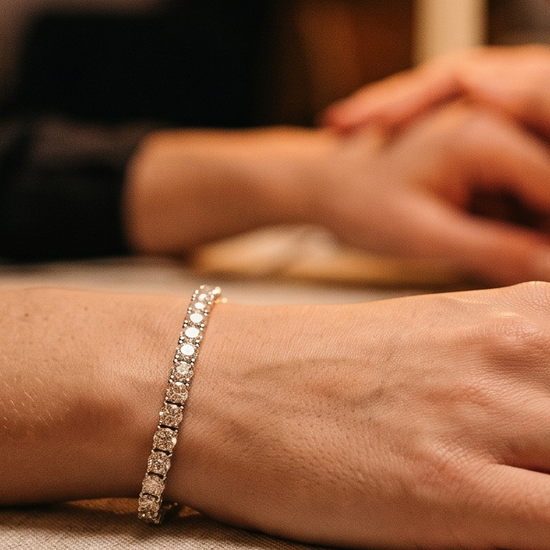 Woman wearing a lab grown diamond tennis bracelet at an anniversary dinner