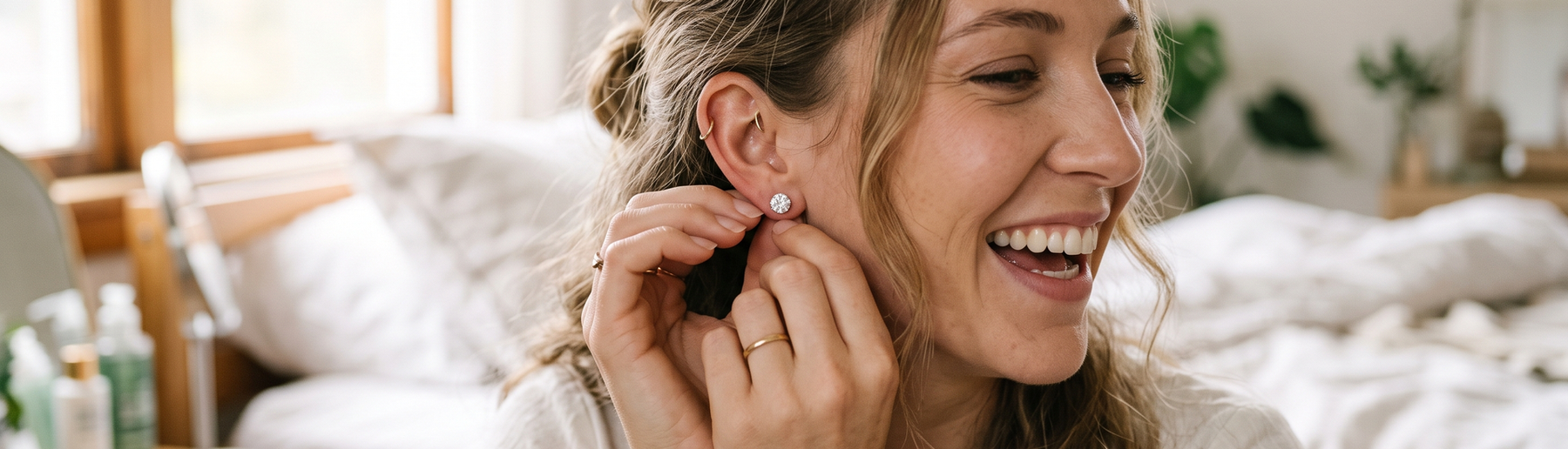 Woman putting on lab-grown diamond stud earrings
