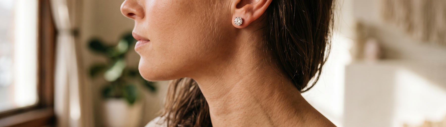 Close-up of a woman wearing lab-grown diamond stud earrings in natural light