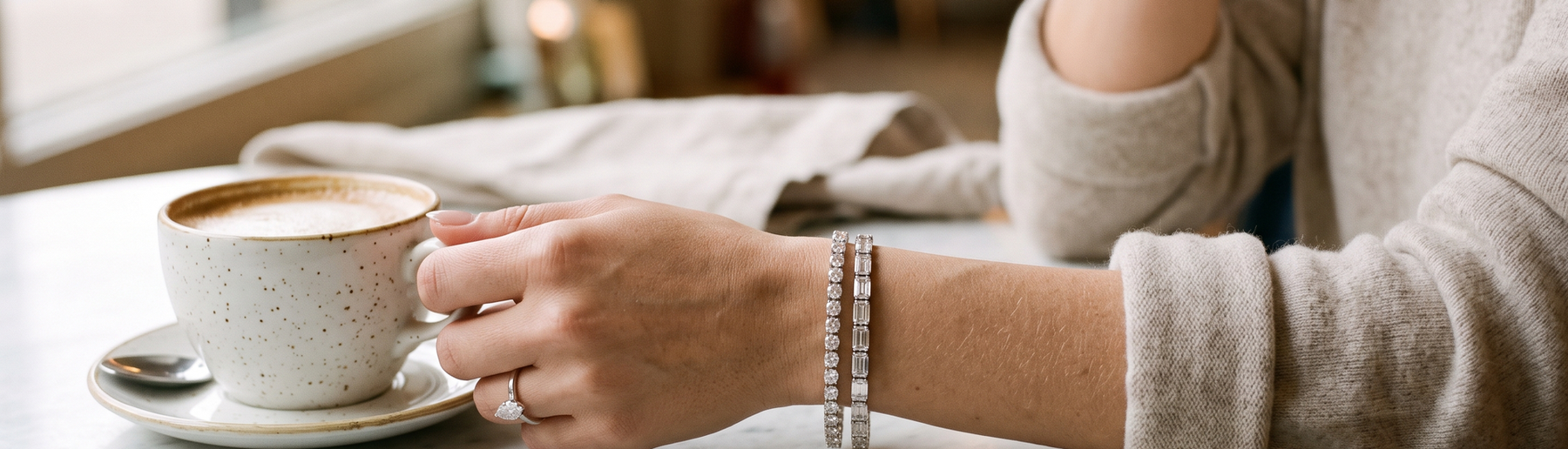 Woman's wrist wearing lab-grown diamond tennis bracelets in white gold and platinum in natural light