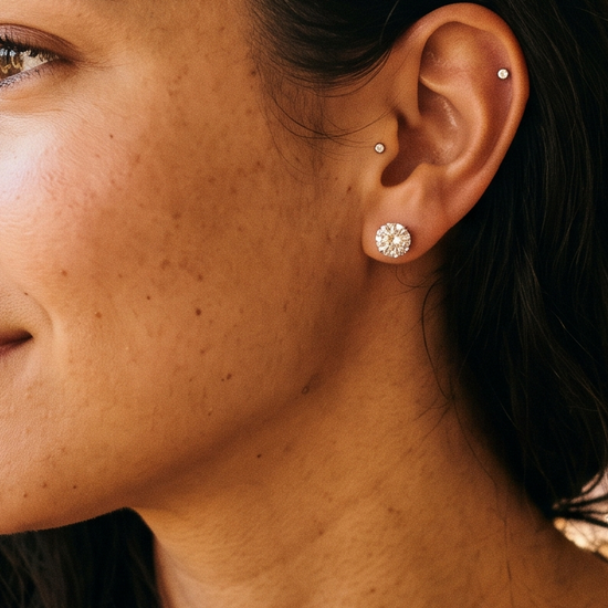 Young woman wearing sparkling lab-grown diamond stud earrings in golden hour light