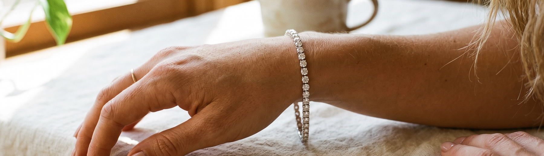 Woman's wrist wearing a sparkling lab-grown diamond tennis bracelet in natural light