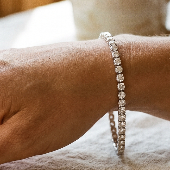 Woman's wrist wearing a sparkling lab-grown diamond tennis bracelet in natural light