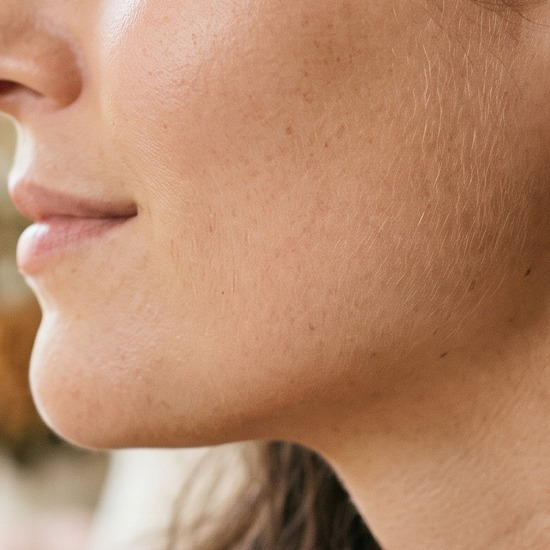 Close-up of a woman's ear wearing lab-grown diamond stud earrings in natural light