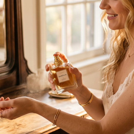 Woman applying luxury perfume at a sunlit vanity