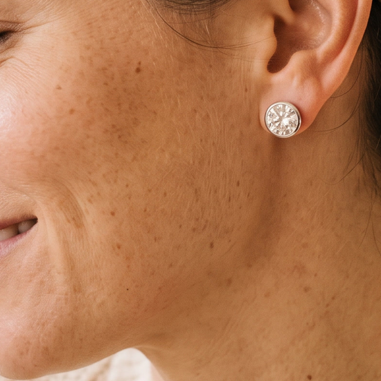 Close-up of a woman wearing lab-grown diamond stud earrings in natural light
