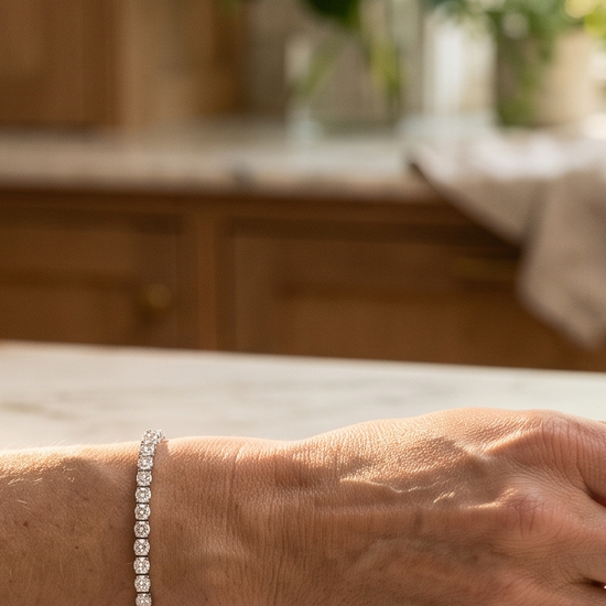 Woman's wrist wearing a lab-grown diamond tennis bracelet in natural morning light