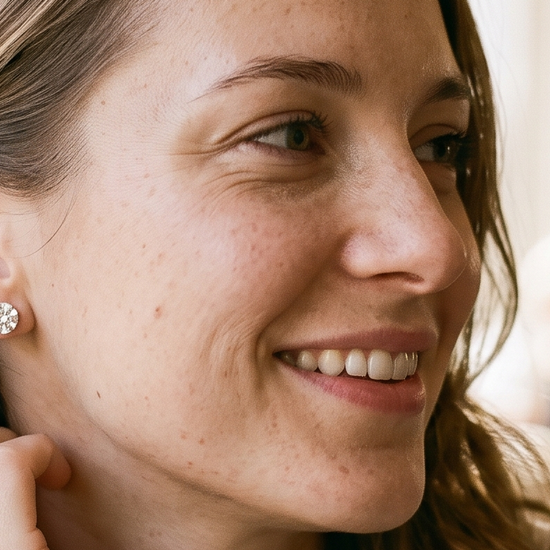 Woman wearing lab-grown diamond stud earrings in natural light