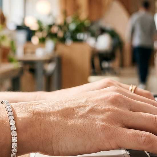 Woman wearing a lab-grown diamond tennis bracelet at her office desk, celebrating a career promotion