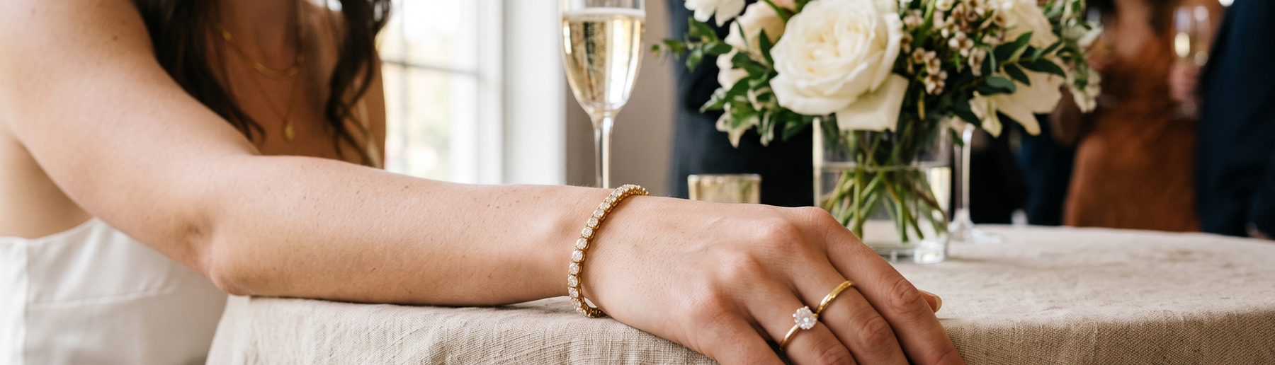 Woman's wrist wearing a lab-grown diamond tennis bracelet at an engagement party