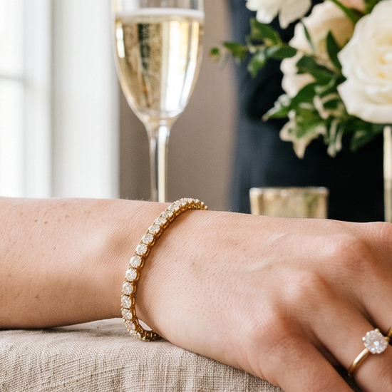 Woman's wrist wearing a lab-grown diamond tennis bracelet at an engagement party