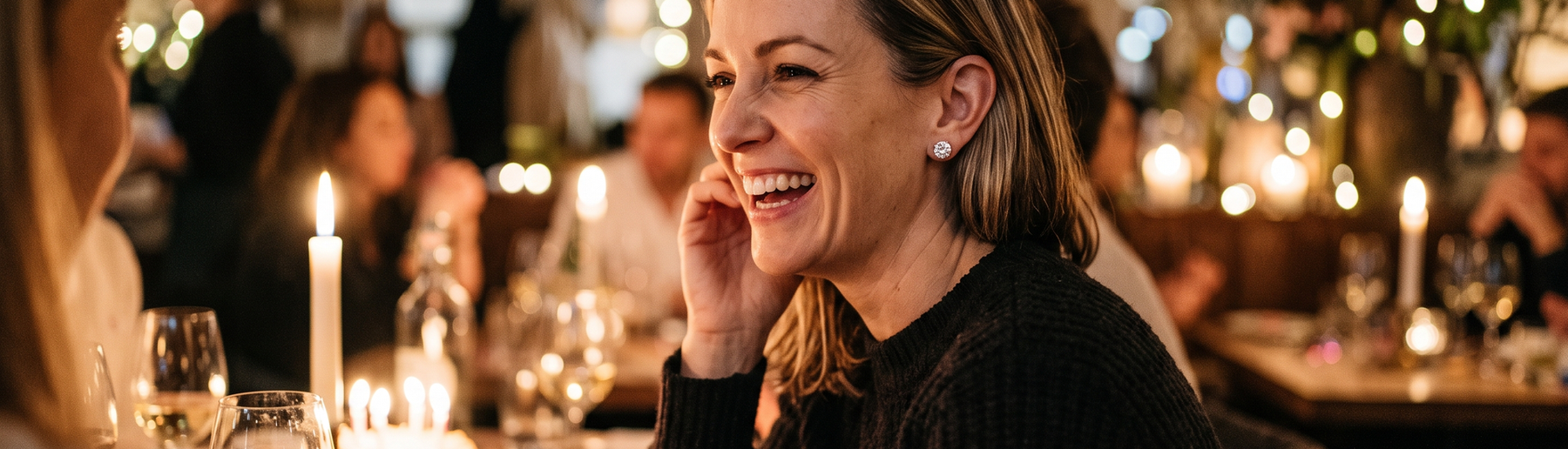 Woman wearing lab-grown diamond stud earrings while laughing at her 40th birthday celebration