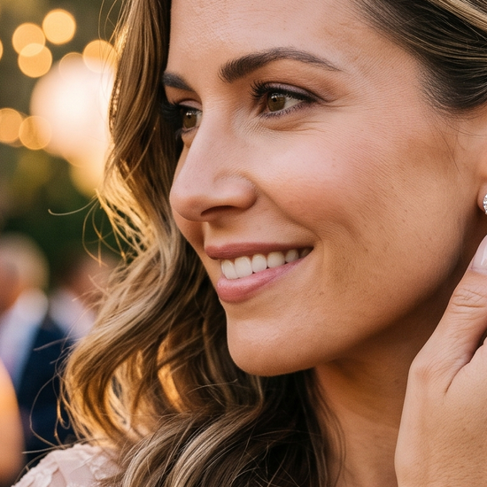 Woman wearing lab-grown diamond stud earrings at an outdoor wedding reception